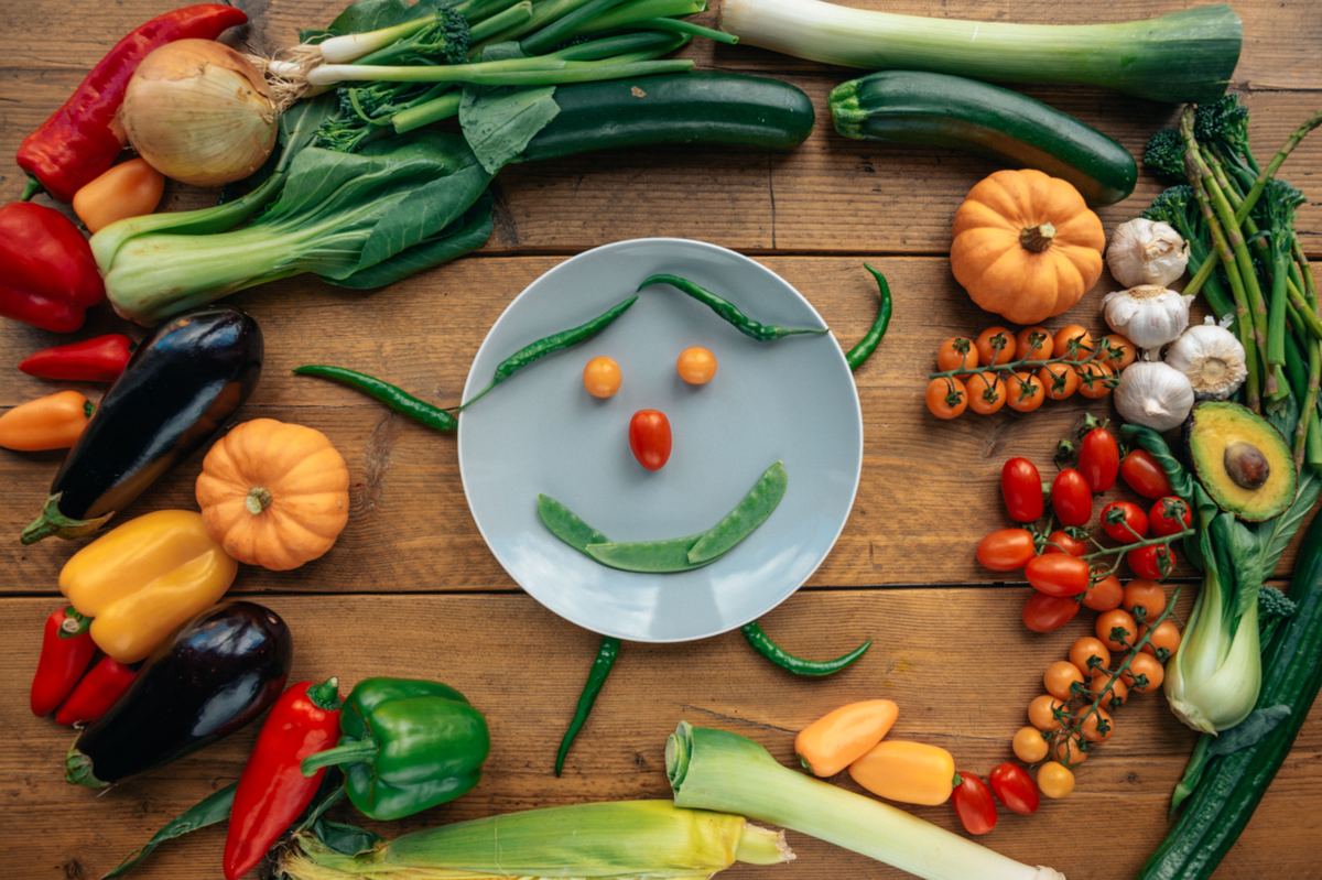 Illustrative stock photograph showing vegetables arranged into a smiling face on a table