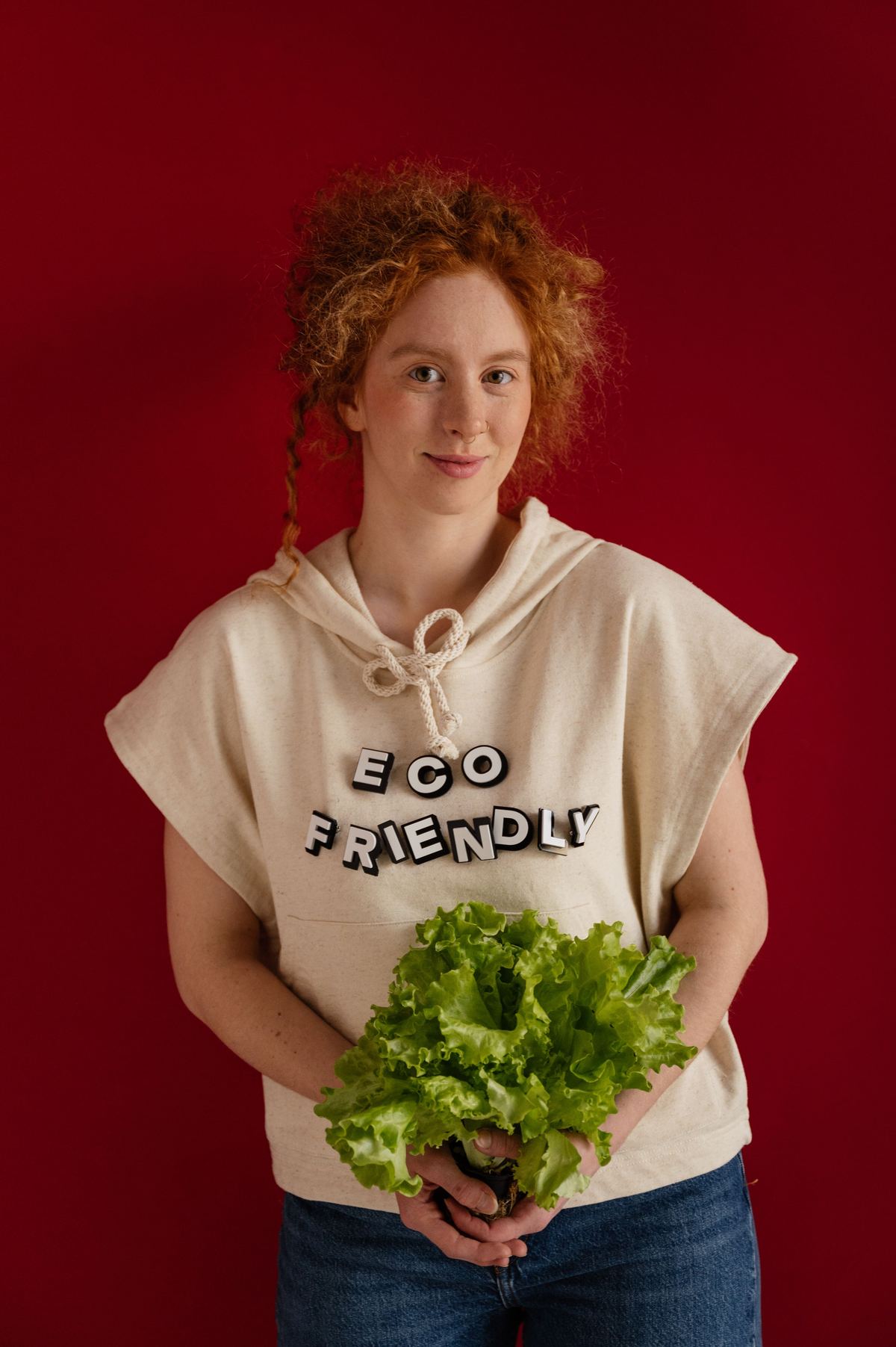 Illustrative stock photograph showing a person wearing an eco friendly shirt holding fresh greens