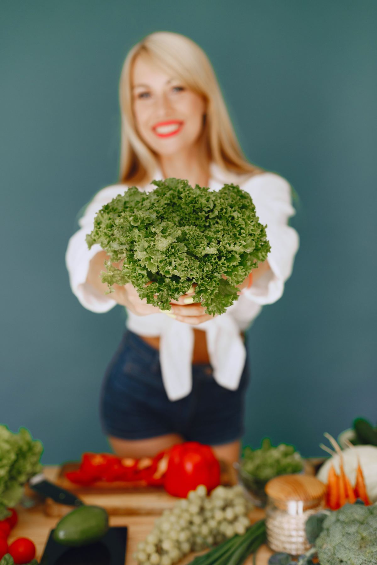 Illustrative stock photograph showing a person holding a bundle of fresh green vegetables